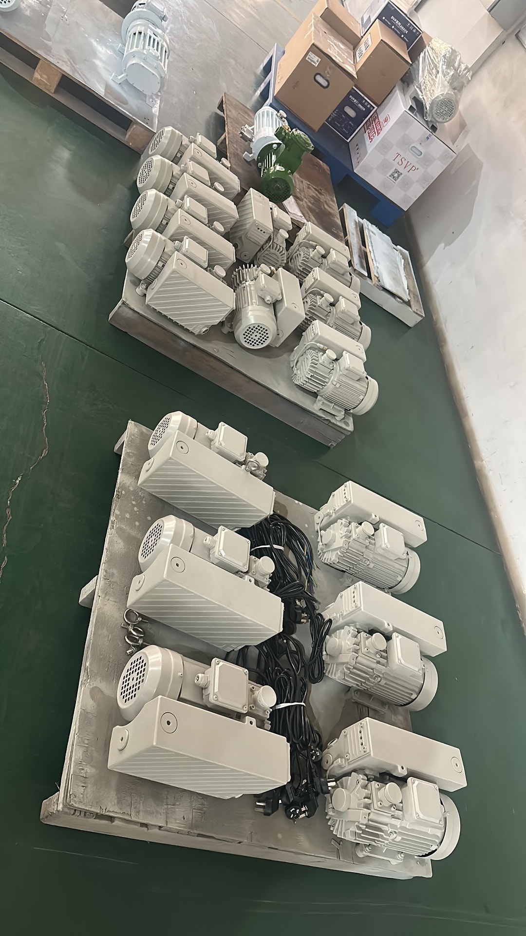Cream-colored rotary vane vacuum pumps arranged in the workshop