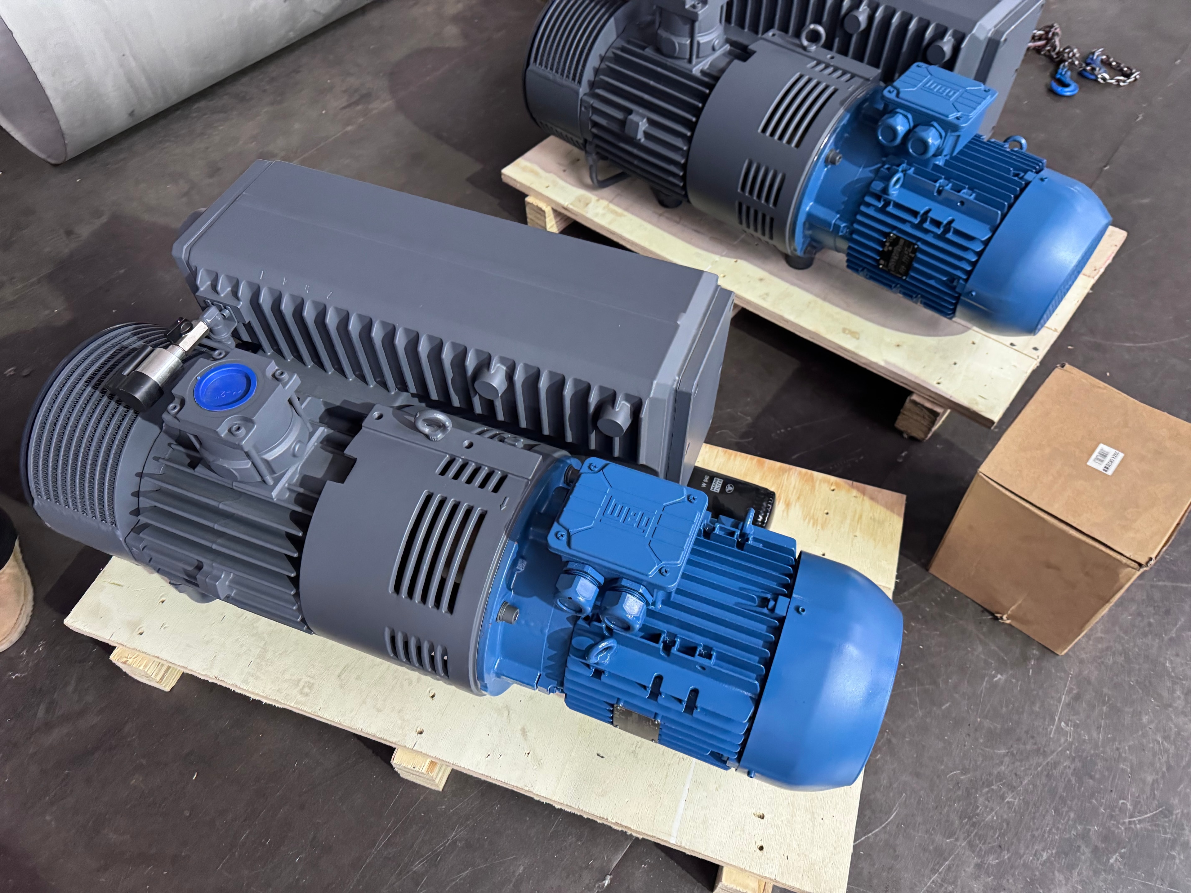 XMV Series oil-sealed rotary vane vacuum pump — blue units on wooden pallets